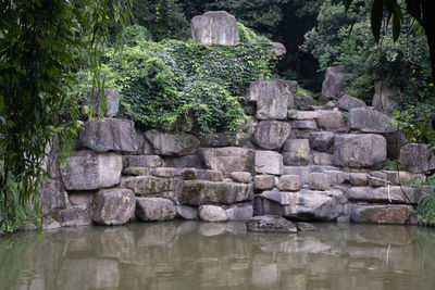 Stone wall by lake in garden