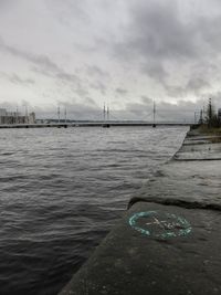 Bridge over river against cloudy sky