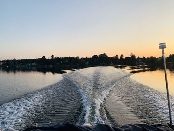 Scenic view of lake against clear sky during sunset