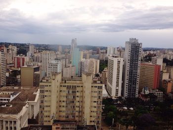 View of cityscape against cloudy sky