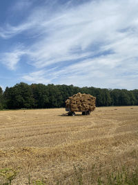 Hay bales on field against sky