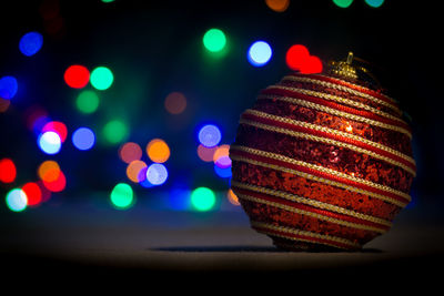 Close-up of bauble against illuminated lights