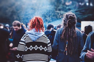 Rear view of people standing against blurred background