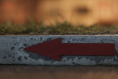 Close-up of arrow sign on wood