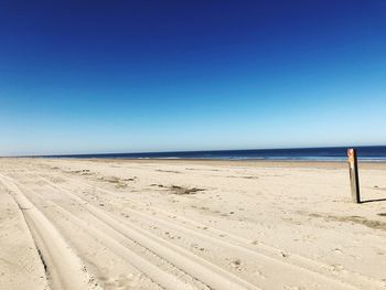 Scenic view of beach against clear blue sky