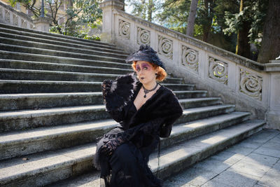 Portrait of young woman sitting on staircase