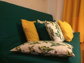 Close-up of cushions arranged on sofa at home