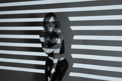Portrait of woman standing against wall