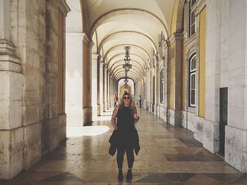 Young woman standing on corridor in building