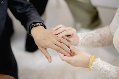 Midsection of couple holding hands
