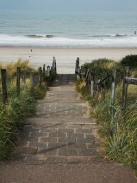 Footpath by sea against sky