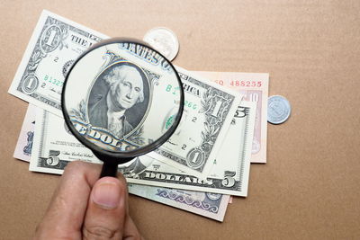 Close-up of hand holding paper against white background