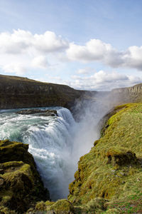 Scenic view of waterfall against sky