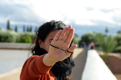 Portrait of woman showing stop gesture