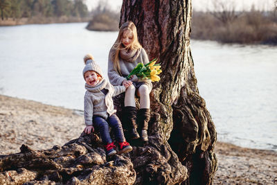 Full length of women on tree trunk