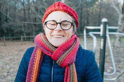 Smiling woman wearing scarf in park