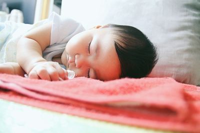 Close-up of boy relaxing on bed at home