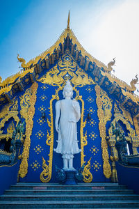 Statue of buddha against blue sky