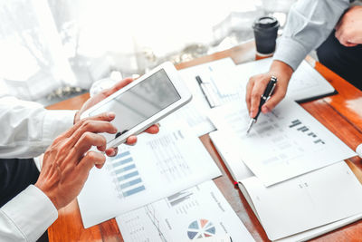 Midsection of business colleagues working on table