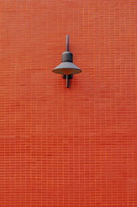 Low angle view of lamp on brick wall