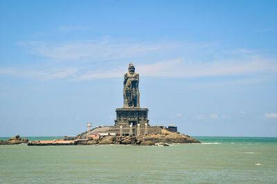 Tower of building by sea against sky