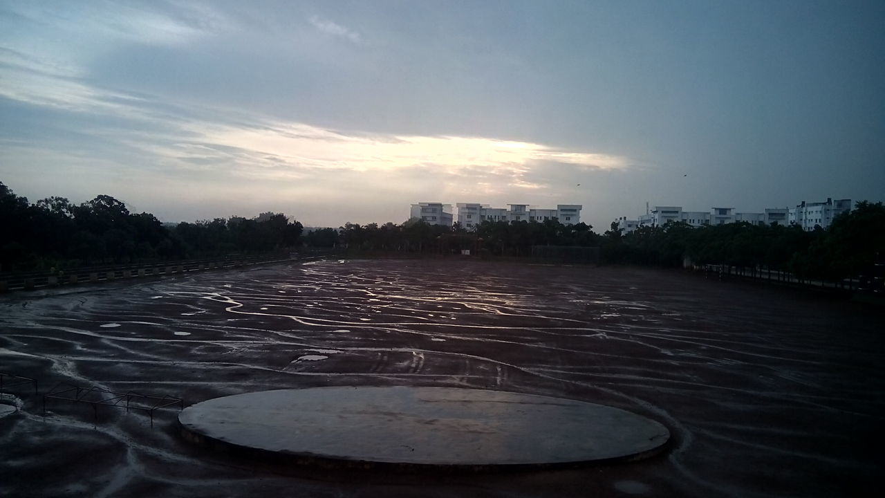 sky, architecture, built structure, water, building exterior, sunset, cloud - sky, city, river, beach, nature, outdoors, dusk, no people, sunlight, tranquility, tree, cloud, surface level, reflection