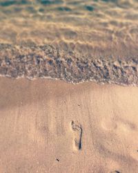 High angle view of footprints on sand at beach