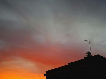 Low angle view of silhouette building against sky during sunset