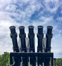 Low angle view of pipes on field against sky