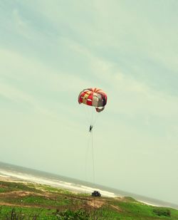 Hot air balloon flying over sea against sky