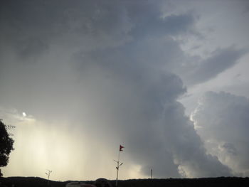 Low angle view of silhouette flag against sky