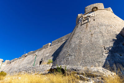 Low angle view of fort against blue sky