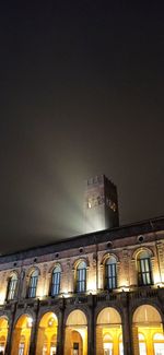 Low angle view of illuminated building against sky at night