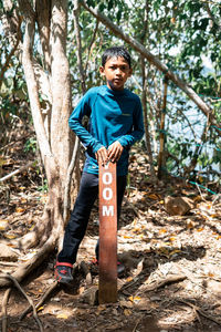 Portrait of young man standing in forest