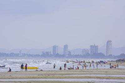 People at beach against clear sky