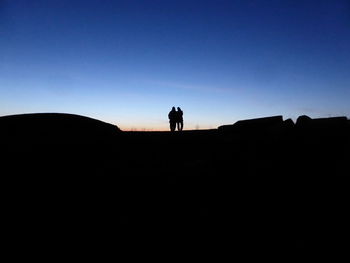 Silhouette man standing against clear sky during sunset