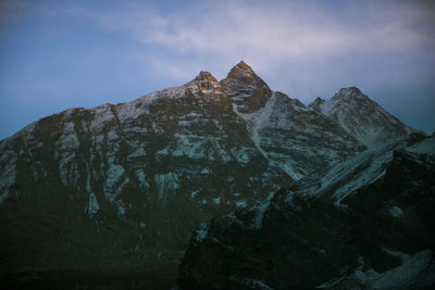 Low angle view of snowcapped mountain against sky