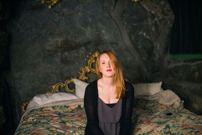 Portrait of beautiful woman sitting on bed