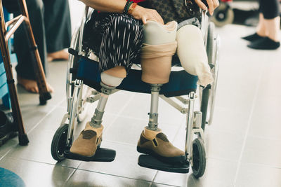 Low section of person with artificial limb on wheelchair