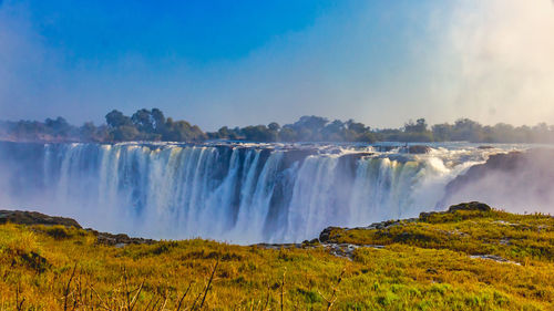 Panoramic view of waterfall against sky