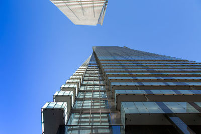 Low angle view of modern building against clear blue sky