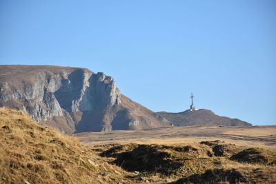 Scenic view of arid landscape against clear blue sky