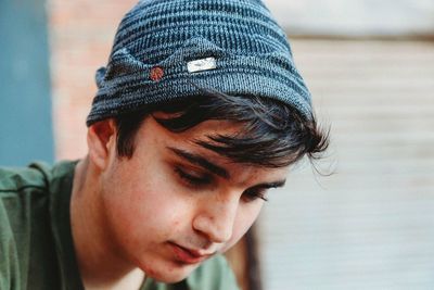 Close-up of thoughtful teenage boy wearing knit hat