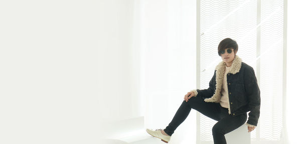 Young woman standing against wall
