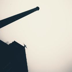 Low angle view of silhouette building against clear sky