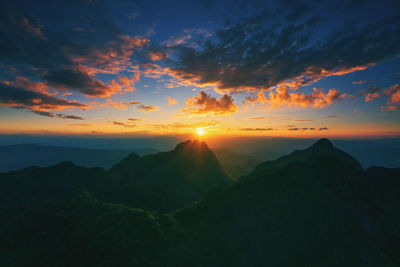 Scenic view of mountains against dramatic sky during sunset