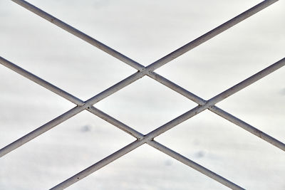 Metal fence with rhombus ornament on grey background, close up. fragment of metal fence