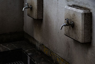 Close-up of old faucet on wall in building