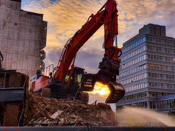 Low angle view of crane at construction site against sky