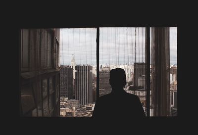 Rear view of silhouette man in glass building